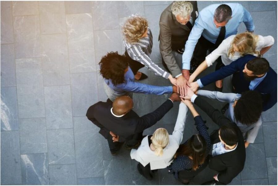 A team placing their hands together to represent trust and long-term partnership